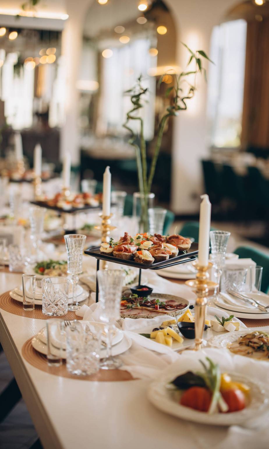 Elegant wedding table setting with appetizers, candles and flowers Long table is set for a wedding reception, featuring appetizers, candles, and floral arrangements, creating a sophisticated and inviting atmosphere